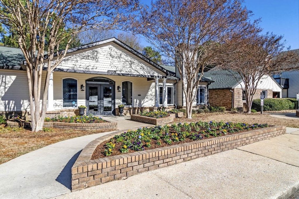 A white house with a brick flower bed in front. A white house with a brick flower bed in front at The Onyx Hoover Apartments, Hoover, AL, 35216